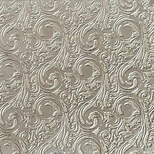 May include: A close-up of two textured metallic sheets with a repeating pattern of stylized floral designs. The sheet on the left is a copper color, while the sheet on the right is a silver color.