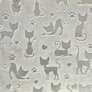 May include: A silver metallic background with a repeating pattern of stylized cats and paw prints.
