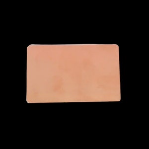 May include: A rectangular, peach-colored object with rounded corners, set against a black background. The item has a smooth, matte finish and appears to be a solid, single-piece construction. The overall shape is a simple rectangle.