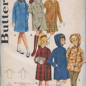 May include: A vintage sewing pattern for a child's coat. The pattern is for sizes 8 and 26. The pattern is for a double-breasted coat with a hood. The pattern is from Butterick and is number 2925. The pattern is 60 cents.