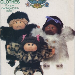 May include: A vintage Cabbage Patch Kids sewing pattern for making clothes. The pattern is for making fur coats for Cabbage Patch Kids dolls. The pattern includes three different styles of coats: a black fur coat, a white fur coat, and a leopard print fur coat. The pattern is from the Butterick company and is number 347.