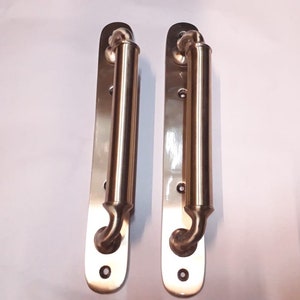 Peut inclure: Deux poignées de porte en nickel brossé avec une plaque arrière rectangulaire et une poignée cylindrique incurvée.