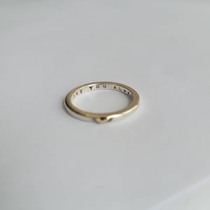 May include: A thin gold band ring with the words "Love You Always" inscribed on the inside of the band. The ring has a small heart-shaped accent on the outside.