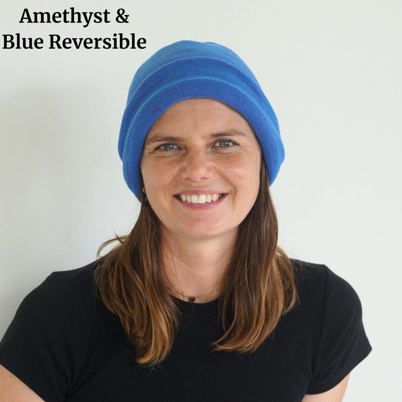 Pu&ograve; includere: Un berretto reversibile blu. Il berretto &egrave; di colore blu unito con una trama a coste. Il testo "Amethyst & Blue Reversible" si trova nell'angolo in alto a sinistra. La persona nell'immagine indossa una maglietta nera.