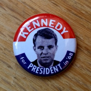 May include: A red, white, and blue button with a portrait of Robert F. Kennedy and the text "Kennedy for President in '68".
