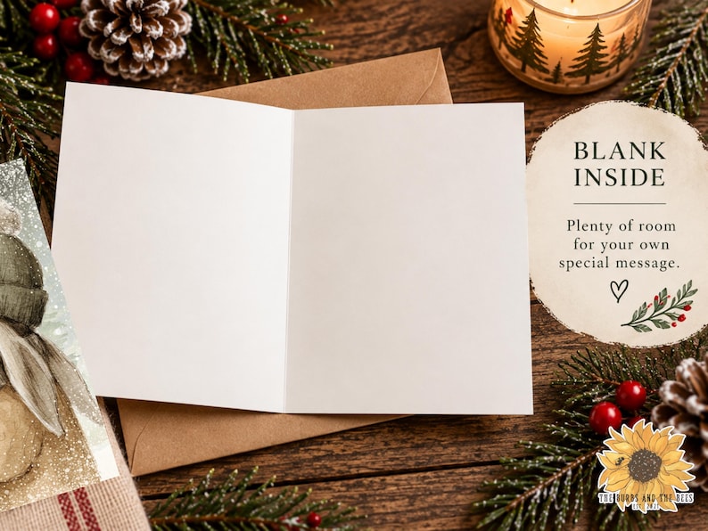 May include: An open greeting card with a blank white interior, resting on a brown envelope. The card features a partial illustration of a figure in a winter hat on the front cover. Text on the right reads: BLANK INSIDE, Plenty of room for your own special message.