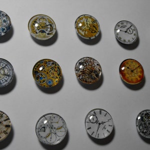 May include: Assortment of 15 round glass cabochons with various clock face designs. The cabochons feature intricate clockwork, Roman numerals, and other decorative elements.