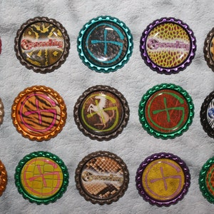 May include: A collection of 15 round, colorful, metal bottle caps with various animal print designs and the word "Geocaching" printed on them. Each cap features a different animal print, including leopard, zebra, giraffe, and snake.
