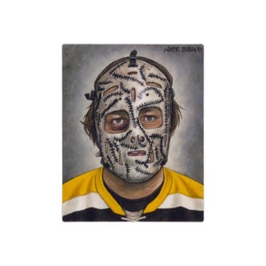 May include: A black and white illustration of a hockey player wearing a vintage goalie mask with a stitched design. The player is wearing a yellow and black hockey jersey. The text "NATE BIBAUD" is in the top right corner of the image.