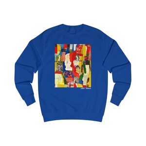 May include: A royal blue sweatshirt with a colorful collage print featuring a variety of images, including a woman's face, a brick wall, and a yellow and red background. The text "NATE BIBAUD" is printed in white at the bottom of the print.