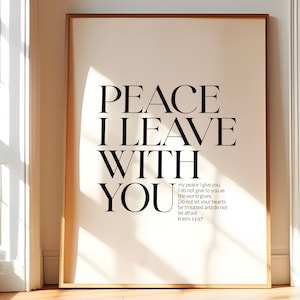 Op de afbeelding: Een ingelijste kunstdruk met de woorden "PEACE I LEAVE WITH YOU" in grote zwarte tekst. De print bevat ook een kleinere passage uit Johannes 14:27. De woorden "DIGITAL DOWNLOAD" staan bovenaan. De lijst is goudkleurig.