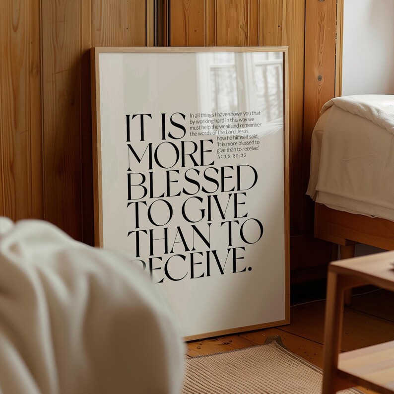 Może przedstawiać: Oprawiony wydruk z tekstem "IT IS MORE BLESSED TO GIVE THAN TO RECEIVE" pogrubioną, elegancką czcionką. Wydruk jest w jasnej drewnianej ramie i jest eksponowany w pokoju z drewnianymi panelami i ł&oacute;żkiem.