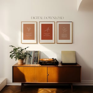 May include: Three framed prints with a brown background and white floral illustrations. The prints feature inspirational quotes: "I had made my mind up to never give up on you", "When darkness is right you just have to wait for it to happen", and "Never will I leave you, never will I forsake you".