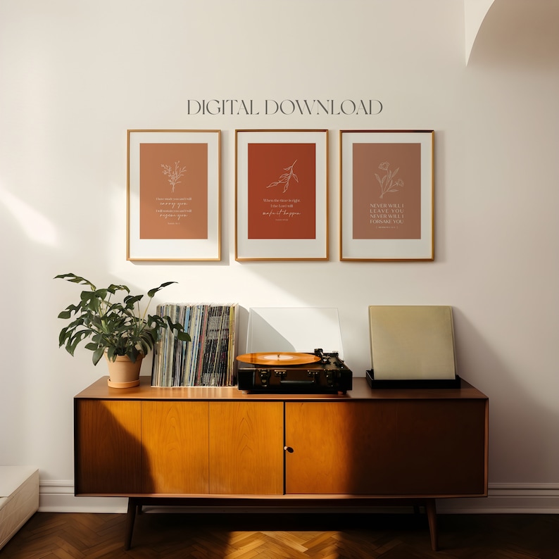 May include: Three framed prints with a brown background and white floral illustrations. The prints feature inspirational quotes: "I had made my mind up to never give up on you", "When darkness is right you just have to wait for it to happen", and "Never will I leave you, never will I forsake you".
