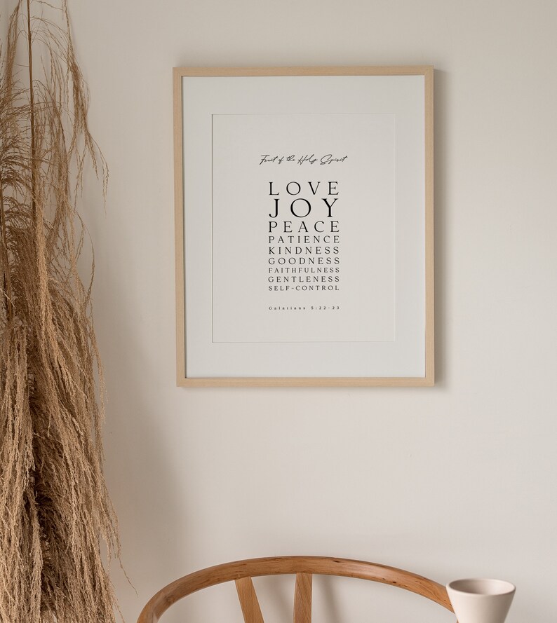 May include: A framed print with a white background and black text. The text reads "Fruit of the Holy Spirit" and lists the following words: Love, Joy, Peace, Patience, Kindness, Goodness, Faithfulness, Gentleness, Self-Control. The text also includes the scripture reference "Galatians 5:22-23".
