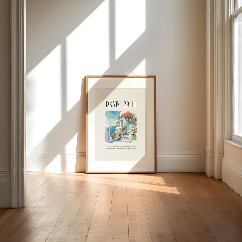 May include: A framed print with a watercolor painting of a building with a blue door and red flowers. The text "PSALM 29:11" is at the top of the print. The text below the painting reads "The Lord gives strength to his people. The Lord blesses his people with peace."