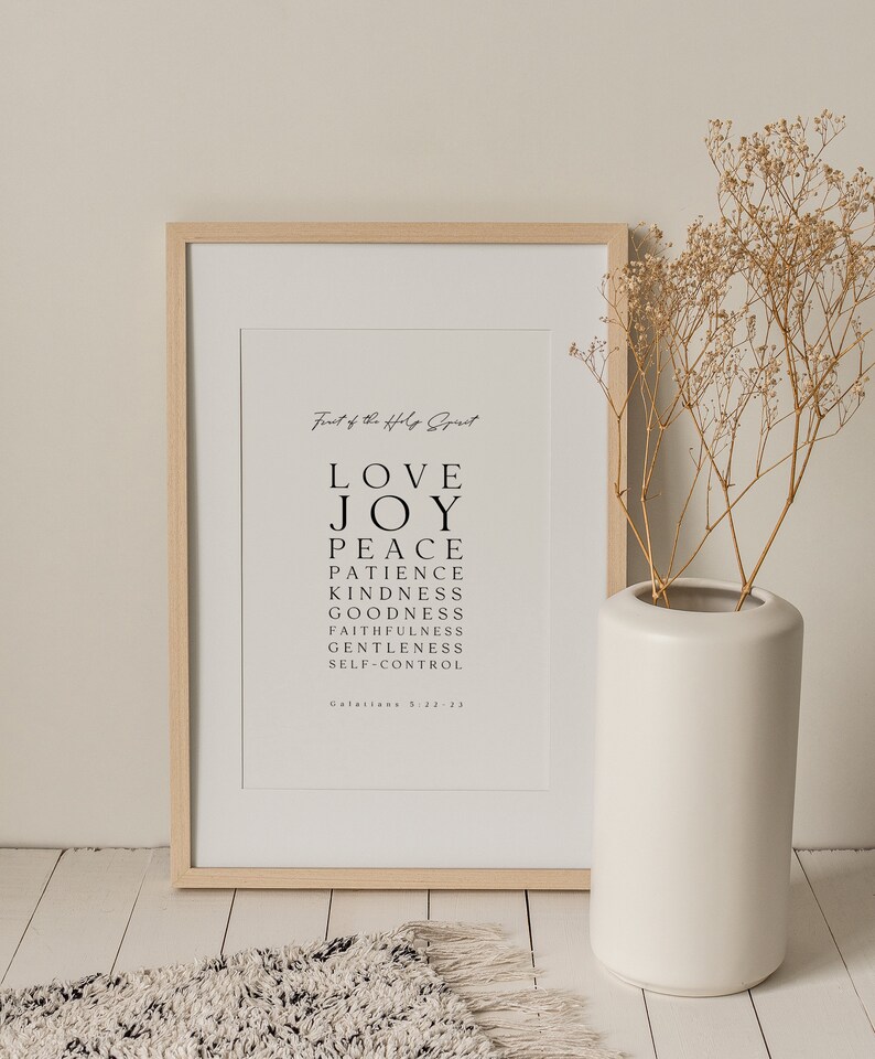 May include: A framed print with a white background and black text. The text reads "Fruit of the Holy Spirit" and lists the following words: Love, Joy, Peace, Patience, Kindness, Goodness, Faithfulness, Gentleness, Self-Control. The text also includes the scripture reference "Galatians 5:22-23".