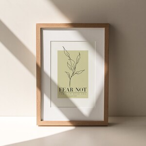 May include: A framed print with a minimalist line drawing of a plant on a light green background. The text "FEAR NOT FOR I AM WITH YOU" is below the plant drawing. The text "Isaiah 41:10" is below the quote.