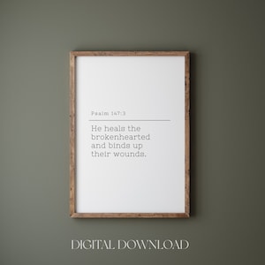 K&ouml;nnte beinhalten: Ein druckbarer digitaler Download mit wei&szlig;em Hintergrund und einem Holzrahmen. Der Text lautet "Psalm 147:3 Er heilt die gebrochenen Herzen und verbindet ihre Wunden."