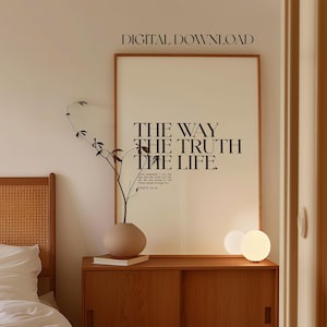 May include: A framed print with the text "THE WAY THE TRUTH THE LIFE. JOHN 14:6" in black text on a beige background. The print is hanging on a wall in a room with a wooden dresser and a vase with a plant.