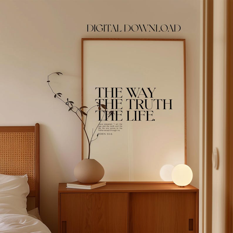 May include: A framed print with the text "THE WAY THE TRUTH THE LIFE. JOHN 14:6" in black text on a beige background. The print is hanging on a wall in a room with a wooden dresser and a vase with a plant.