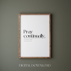 May include: A printable digital download of a minimalist black and white quote poster with the text "Pray continually. Pray without ceasing. 1 Thessalonians 5:17". The poster is framed in a brown wood frame and is displayed against a green wall.
