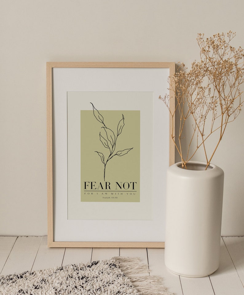 May include: A framed print with a green background and a black line drawing of a branch with leaves. The text "FEAR NOT FOR I AM WITH YOU Isaiah 41:10" is printed in black below the drawing.
