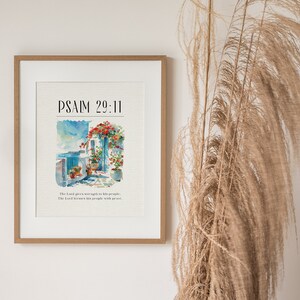May include: A framed print with a watercolor painting of a building with flowers and the text "PSALM 29:11" and the text "The Lord gives strength to his people. The Lord blesses his people with peace."