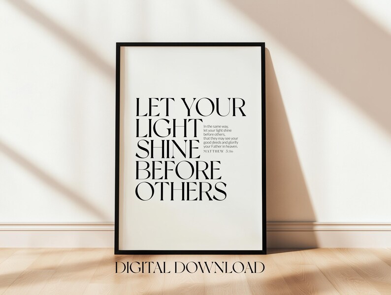 May include: Black framed print with the text "LET YOUR LIGHT SHINE BEFORE OTHERS" in a bold, elegant font. The words "DIGITAL DOWNLOAD" are at the bottom. The print is displayed on a light-colored wall and wooden floor.