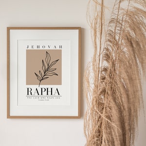 May include: A framed print with a brown background and a black line drawing of a leaf. The text "Jehovah Rapha" is printed in black with the phrase "The Lord who heals you" in smaller font below.