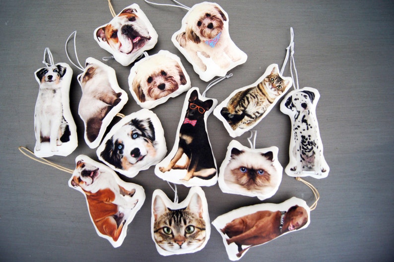 Peut inclure: Une collection de d&eacute;corations de No&euml;l sur le th&egrave;me des animaux de compagnie, repr&eacute;sentant diverses races de chiens et de chats. Chaque ornement est une forme douce et moelleuse avec une image d&eacute;taill&eacute;e d'un chien ou d'un chat, avec des boucles pour suspendre.