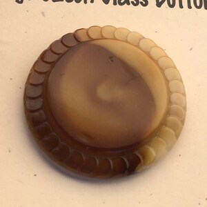 May include: A brown and cream vintage Czech glass button with a scalloped edge.