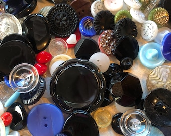 May include: A large collection of vintage buttons in various colors, shapes, and sizes. The buttons are made of glass, plastic, and metal. Some of the buttons have intricate designs, while others are plain. The buttons are a great addition to any craft project or sewing kit.