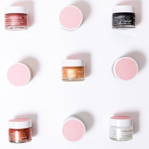 May include: Overhead view of small glass jars of calligraphy ink with white lids and pink labels. The ink colours vary, including pinks, gold, and black. The jars are arranged on a white surface, creating a clean, minimalist aesthetic.