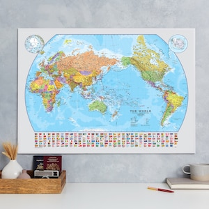 May include: A world map poster with a blue background and a white border. The map shows the continents and oceans of the world. The poster also includes a row of flags representing different countries. The text "THE WORLD" is printed at the bottom of the map.