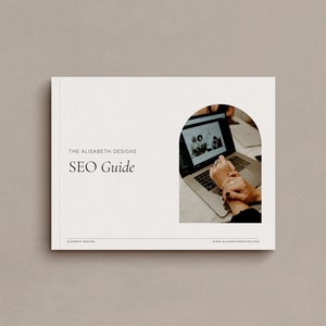 May include: A white guide with the text "The Alisabeth Designs SEO Guide" in black text. The guide features a photo of a person's hands on a laptop with a screen showing a photo of a group of people.