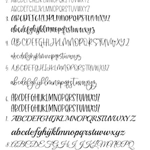May include: A black and white image of a handwritten font alphabet. The font is a cursive script style. The alphabet is displayed in both uppercase and lowercase letters.
