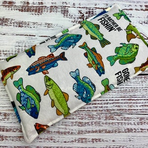 May include: White fabric heat pack with a colorful fish print. The text "I'd rather be fishin'" and "Gone Fishin'" is printed on the fabric.