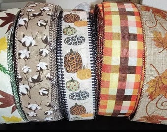 May include: Five rolls of decorative ribbon with autumn-themed patterns. The ribbons feature designs of pumpkins, leaves, cotton bolls, and plaid.