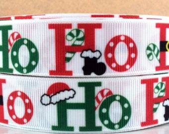 May include: White ribbon with a repeating pattern of red "Ho Ho" text, green wreaths, candy canes, and Santa hats.