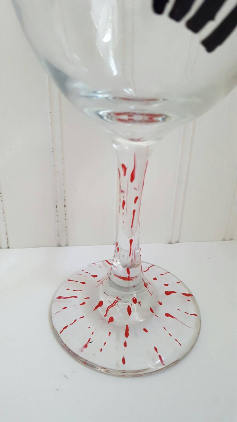 Pu&ograve; includere: Un bicchiere da vino in vetro trasparente con un motivo a spruzzo rosso sulla base e sul gambo.