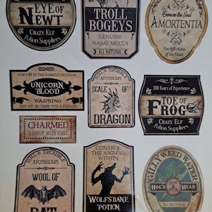 May include: Nine vintage-style potion bottle labels with whimsical illustrations and text. The labels feature names like "Eye of Newt", "Troll Bogeys", "Amortentia", "Unicorn Blood", "Scale of Dragon", "Charmed", "Wool of Bat", "Wolfsbane Potion", "Gillyweed Water", and "Toe of Frog".