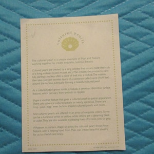 May include: A white card with a green illustration of a seashell and the text "cultured pearls". The card explains how cultured pearls are created by a mollusk and describes the different shapes, colors, and sizes of cultured pearls.