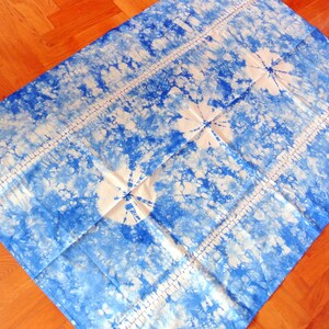 Peut inclure: Un tissu blanc avec un motif tie-dye bleu. Le tissu a une texture subtile et une apparence légèrement délavée.