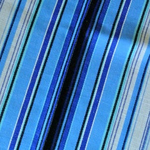 May include: Blue and white striped fabric with a diagonal pattern. The fabric has a subtle texture and a soft, woven look.