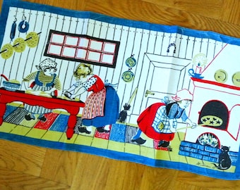Könnte beinhalten: Ein rechteckiges Küchentuch mit blauem Rand und einer farbenfrohen Illustration von drei Personen in traditioneller Kleidung beim Backen in einer Küche. Die Szene zeigt einen roten Tisch, einen weißen Ofen mit Feuer und eine schwarze Katze.