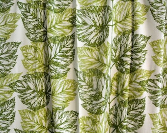 May include: White fabric with a green leaf pattern. The leaves are outlined in a darker green and have a slightly textured look.