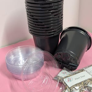 May include: A set of black plastic plant pots, clear plastic saucers, and small bags of plant food. The plant food bags have labels that say "Plant Food".