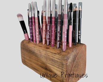 May include: Wooden makeup pencil holder with 16 holes, filled with various colored lip liners and a few black eyeliner pencils. The holder is made of rustic wood and has the text "Unique Primtiques" on the bottom.