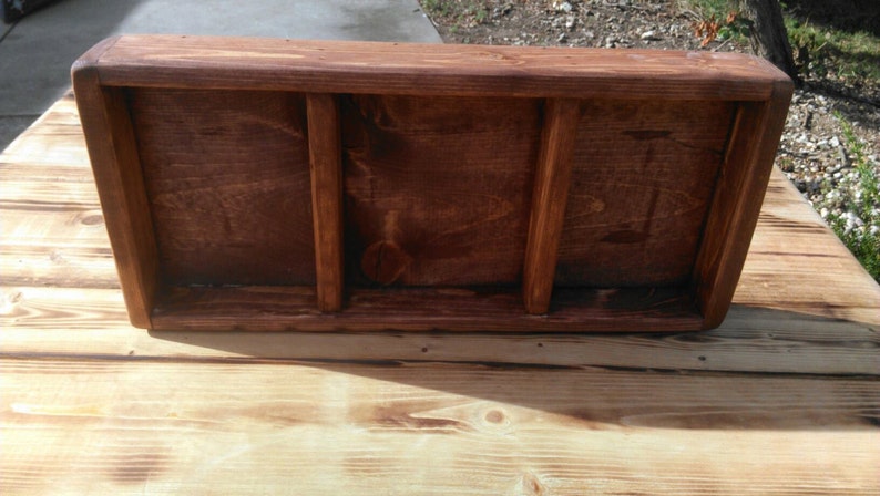 Puede incluir: Una bandeja de madera con tres compartimentos. La bandeja est&aacute; te&ntilde;ida de un color marr&oacute;n oscuro y tiene un aspecto r&uacute;stico.